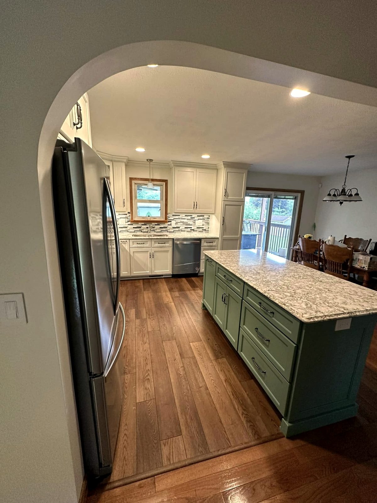 Renovated kitchen with painted island and archway